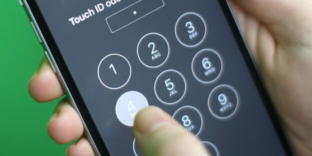 Ein Finger tippt einen Zahlencode in ein Telefon Ein Finger tippt einen Zahlencode in ein Telefon