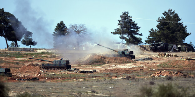 Eine Artilleriepanzer feuert unter Rauchschwaden einen Schuss ab Eine Artilleriepanzer feuert unter Rauchschwaden einen Schuss ab
