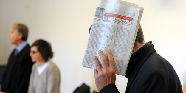 Christian Klar verdeckt sein Gesicht mit einer Zeitung Christian Klar verdeckt sein Gesicht mit einer Zeitung