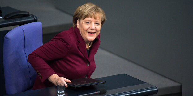 Frau steht im Plenarsaal des Bundestages und lacht. Frau steht im Plenarsaal des Bundestages und lacht.