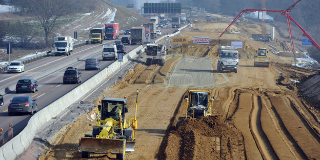 Auf einer Autobahnbaustelle wird mit Baggern und Planierraupen gearbeitet. Auf einer Autobahnbaustelle wird mit Baggern und Planierraupen gearbeitet.