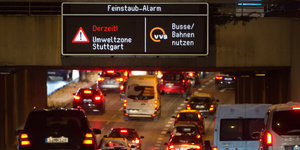 Autos fahren auf einer mehrspurigen Straße, darüber ein Schild, das den Feinstaub-Alarm anzeigt