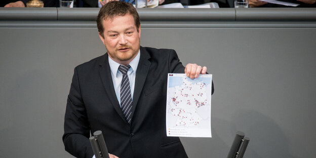 Der SPD-Abgeordnete Uli Grötsch steht an einem Rednerpult und hält eine Karte mit vielen Punktmarkierungen in der Hand Der SPD-Abgeordnete Uli Grötsch steht an einem Rednerpult und hält eine Karte mit vielen Punktmarkierungen in der Hand