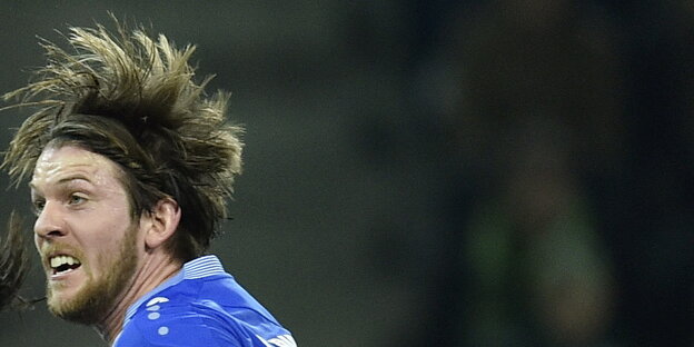 ein Mann mit wilden Haaren in einem blauen Trikot ein Mann mit wilden Haaren in einem blauen Trikot