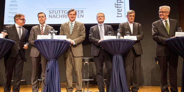 Sechs Männer an Stehtischen Sechs Männer an Stehtischen