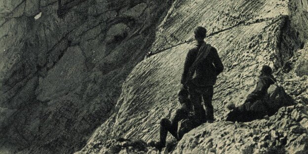 Drei Menschen vor einer Bergwand, schwarz-weiß-Aufnahme Drei Menschen vor einer Bergwand, schwarz-weiß-Aufnahme