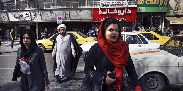 zwei Frauen (beide mit Kopftuch) und ein Mann (mit Turban) überqueren eine Straße zwei Frauen (beide mit Kopftuch) und ein Mann (mit Turban) überqueren eine Straße