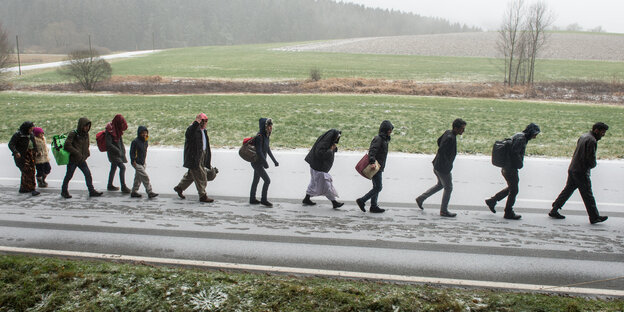 Menschen laufen in einer Reihe auf einer Straße Menschen laufen in einer Reihe auf einer Straße