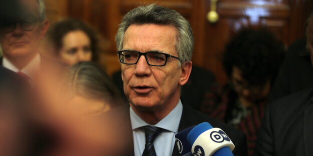 Thomas de Maizière vor einem Mikrofon Thomas de Maizière vor einem Mikrofon