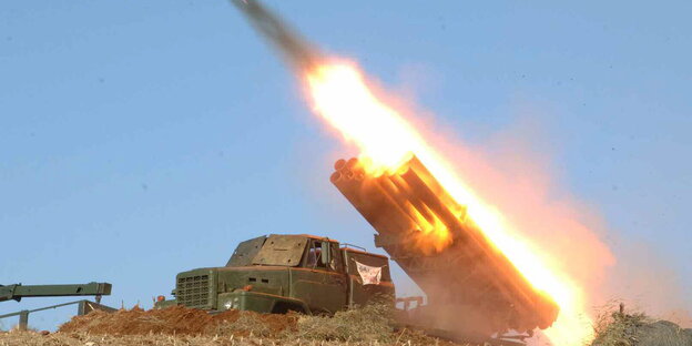 Der Feuerschweif einer Rakete leuchtet an der Abschussrampe auf. Daneben steht ein Militärfahrzeug. Der Feuerschweif einer Rakete leuchtet an der Abschussrampe auf. Daneben steht ein Militärfahrzeug.