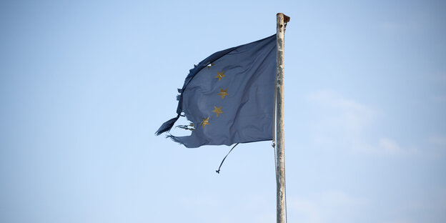 Eine zerrissene blaue EU-Fahne weht im Wind Eine zerrissene blaue EU-Fahne weht im Wind