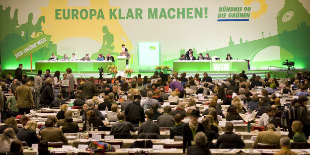 Menschen sitzen an Tischen, dahinter Bühne mit großem Transparent, auf dem steht "Europa klarmachen - Bündnis 90 / Die Grünen" Menschen sitzen an Tischen, dahinter Bühne mit großem Transparent, auf dem steht "Europa klarmachen - Bündnis 90 / Die Grünen"