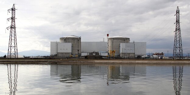 Hinter einem Fluss stehen zwei Meiler eines Atomkraftwerks