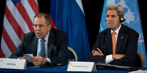 Sergej Lawrow und John Kerry sitzen vor einer UN-Flagge