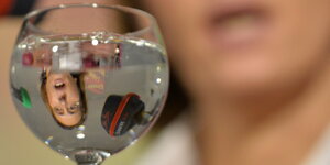 Eine Frau spiegelt sich in einem Glas