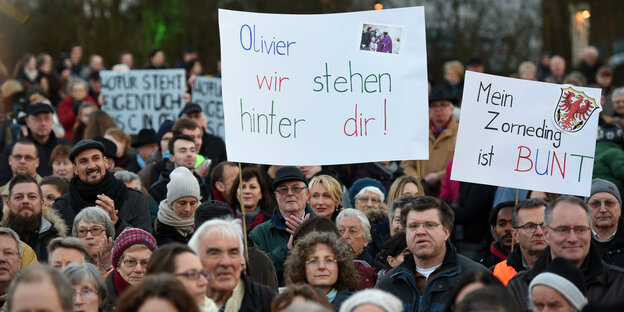 Eine Menschenmenge hält Plakate in die Höhe Eine Menschenmenge hält Plakate in die Höhe
