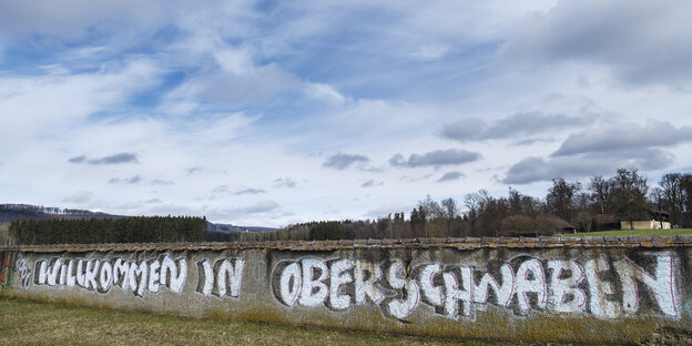 Ein Graffito auf einer Mauer unter blauem Himmel Ein Graffito auf einer Mauer unter blauem Himmel