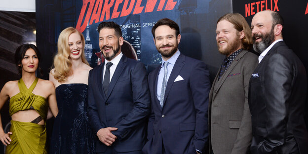 Vor einem Daredevil-Poster stehen Elodie Yung, Deborah Ann Woll, Jon Bernthal, Charlie Cox, Elden Henson und Geoffrey Cantor Vor einem Daredevil-Poster stehen Elodie Yung, Deborah Ann Woll, Jon Bernthal, Charlie Cox, Elden Henson und Geoffrey Cantor