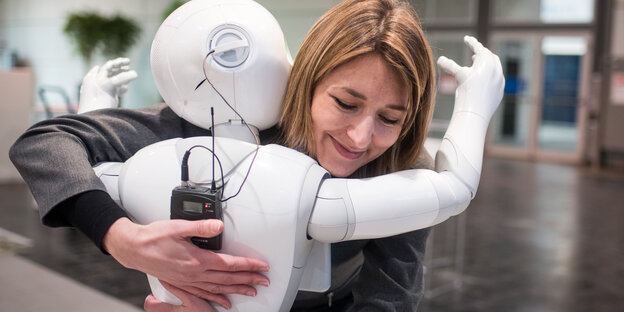 Ein Roboter umarmt eine Frau Ein Roboter umarmt eine Frau