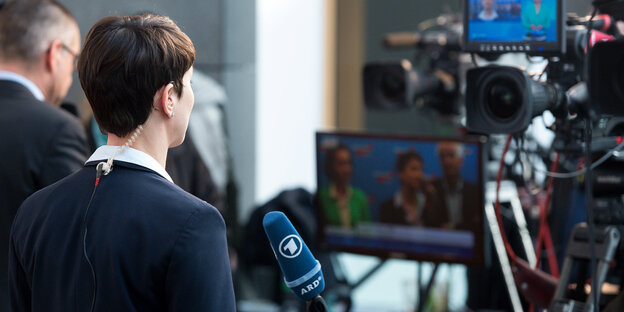 Frauke Petry ist von hinten zu sehen. Sie steht vor Kameras. Frauke Petry ist von hinten zu sehen. Sie steht vor Kameras.