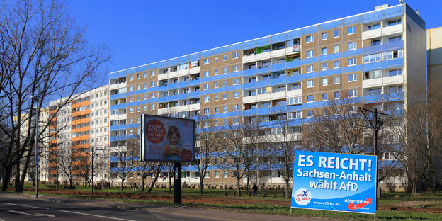 ein Plattenbau bei sonnigem Wetter, im Vordergrund ein Wahlplakat der AfD mit dem Slogan „Es reicht - Sachsen-Anhalt wählt AfD“ ein Plattenbau bei sonnigem Wetter, im Vordergrund ein Wahlplakat der AfD mit dem Slogan „Es reicht - Sachsen-Anhalt wählt AfD“