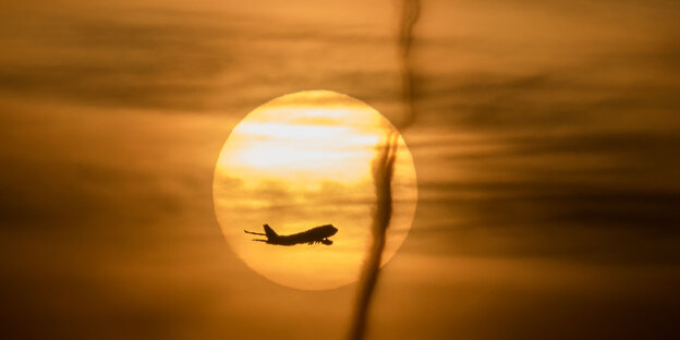 Ein gelblicher Morgenhimmel mit Sonne und Flugzeug Ein gelblicher Morgenhimmel mit Sonne und Flugzeug