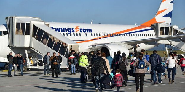 Geflüchtete aus Albanien gehen zu einem Flugzeug auf dem Flughafen Calden bei Köln. Geflüchtete aus Albanien gehen zu einem Flugzeug auf dem Flughafen Calden bei Köln.
