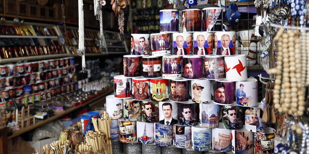 Tassen mit Porträts von Bashar Al-Assad, Wladimir Putin und Hassan Nassrallah sind zu einer Pyramide aufgestapelt. Tassen mit Porträts von Bashar Al-Assad, Wladimir Putin und Hassan Nassrallah sind zu einer Pyramide aufgestapelt.