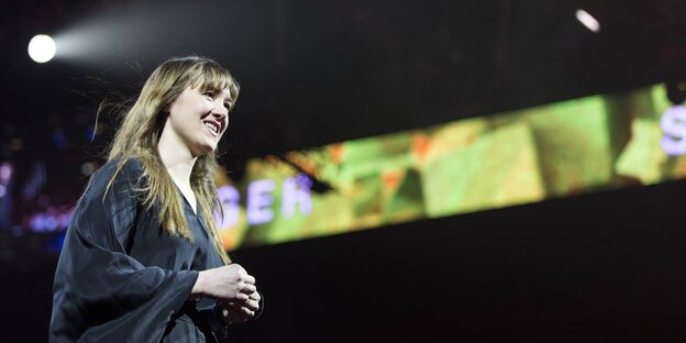Sophie Hunger steht auf der Bühne. Hinter ihr bunte Bildschirme Sophie Hunger steht auf der Bühne. Hinter ihr bunte Bildschirme
