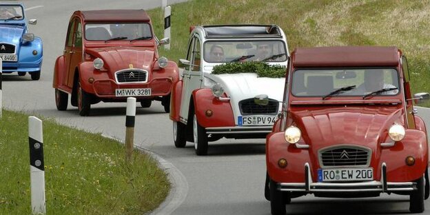 Mehrere Citroens 2CV auf einer Landstraße