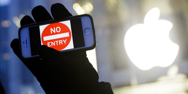 eine schwarzbehandschuhte Hand hält ein Smartphone mit einem „Einfahrt verboten“-Schild auf dem Display eine schwarzbehandschuhte Hand hält ein Smartphone mit einem „Einfahrt verboten“-Schild auf dem Display