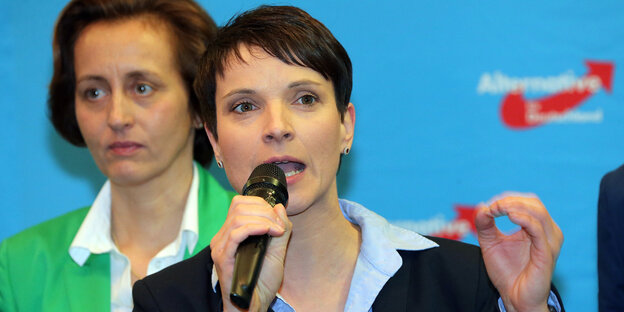 Frauke Petry spricht in ein Mikrofon, im Hintergrund steht Beatrix von Storch Frauke Petry spricht in ein Mikrofon, im Hintergrund steht Beatrix von Storch