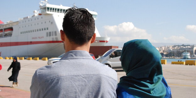 Der Rücken eines Paares, sie blicken auf ein Schiff Der Rücken eines Paares, sie blicken auf ein Schiff