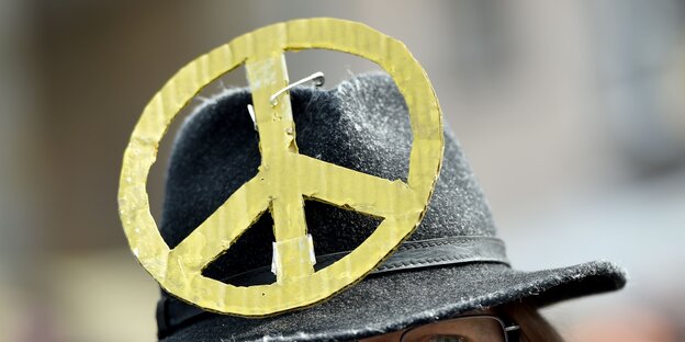 Ein Peace-Zeichen ist an einem schwarzen Hut befestigt. Ein Peace-Zeichen ist an einem schwarzen Hut befestigt.