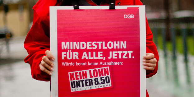 Auf einem roten Schild steht „DGB. Mindestlohn für alle, jetzt. Würde kennt keine Ausnahmen: Kein Lohn unter 8,50 Euro pro Stunde“