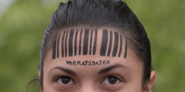 Demonstrantin gegen Vorratsdatenspeicherung mit Zeichnung eines Barcodes auf der Stirn Demonstrantin gegen Vorratsdatenspeicherung mit Zeichnung eines Barcodes auf der Stirn