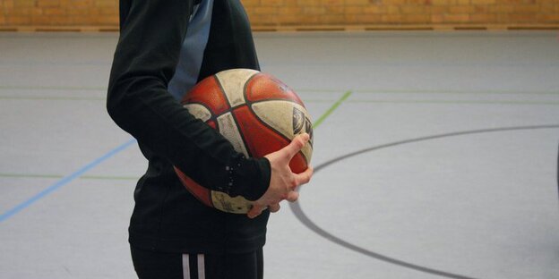 Ein Junge mit Ball in der Hand in der Turnhalle Ein Junge mit Ball in der Hand in der Turnhalle