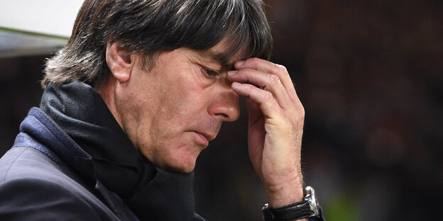 Ein Mann mit dunklen Haaren und dunklem Jacket, es ist Joachim Löw, fasst sich an die Stirn Ein Mann mit dunklen Haaren und dunklem Jacket, es ist Joachim Löw, fasst sich an die Stirn