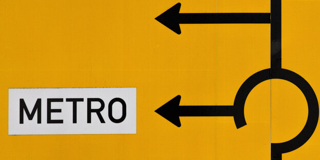 Ein Straßenschild mit zwei Abbiegepfeilen nach links, an einem steht Metro Ein Straßenschild mit zwei Abbiegepfeilen nach links, an einem steht Metro