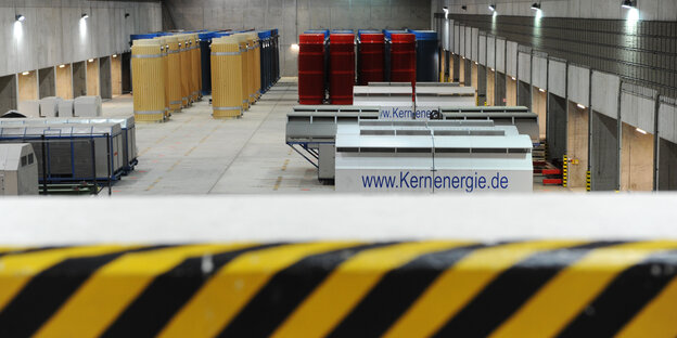 In einer Halle stehen bunte Zylinder und weiße Kästen mit der Aufschrift "Kernenergie" In einer Halle stehen bunte Zylinder und weiße Kästen mit der Aufschrift "Kernenergie"
