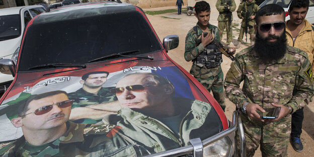 Soldaten stehen neben einem Auto, auf dem Bilder von Assad und Putin aufgeklebt sind Soldaten stehen neben einem Auto, auf dem Bilder von Assad und Putin aufgeklebt sind