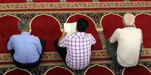 Drei Männer beten in einer Moschee Drei Männer beten in einer Moschee