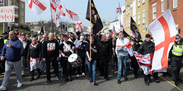 Demonstranten tragen Trommeln und Fahnen mit sich Demonstranten tragen Trommeln und Fahnen mit sich