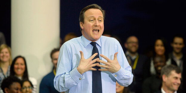 Ein Mann hält seine Hände vor die Brust, es ist David Cameron Ein Mann hält seine Hände vor die Brust, es ist David Cameron