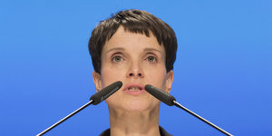 Eine Frau mit zwei Mikrofonen vorm Gesicht, es ist Frauke Petry