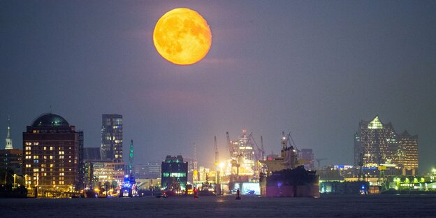 Der Vollmond scheint über dem Hamurger Hafen, links im Bild ist ein Altenheim des Augustinum-Konzerns zu sehen.