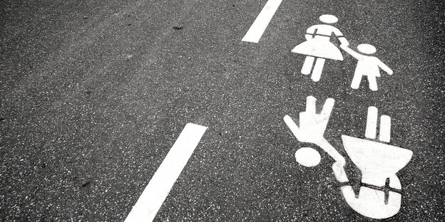 Ein Mutter-Kind-Verkehrszeichen ist auf eine Straße gemalt Ein Mutter-Kind-Verkehrszeichen ist auf eine Straße gemalt