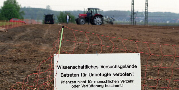 Ein Acker mit einem Schild, dass darauf hinweist, dass die Pflanzen allein der wissenschaftlichen Forschung dienen Ein Acker mit einem Schild, dass darauf hinweist, dass die Pflanzen allein der wissenschaftlichen Forschung dienen