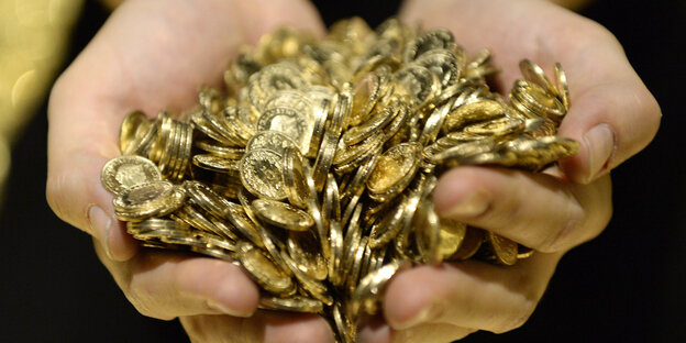 Goldmünzen in den Händen Goldmünzen in den Händen