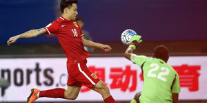 Chinesischer Fußballer schießt Ball